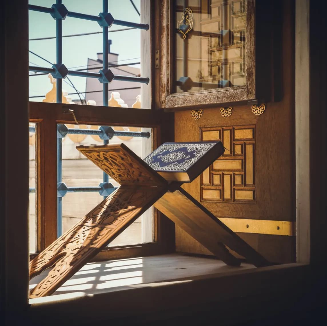 A Qur’an resting beside a window in warm natural light